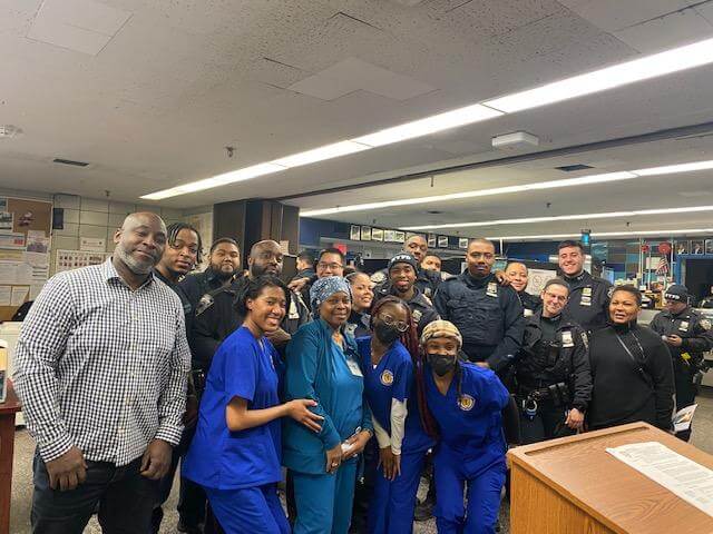 Officers and nurses posing together at a screening event
