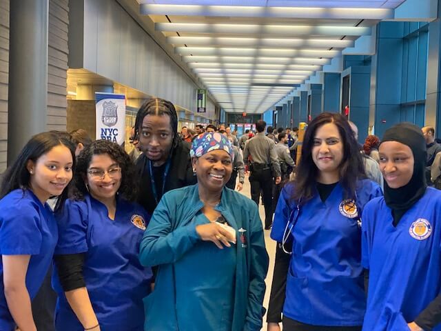 Nurses in blue scrubs posing together