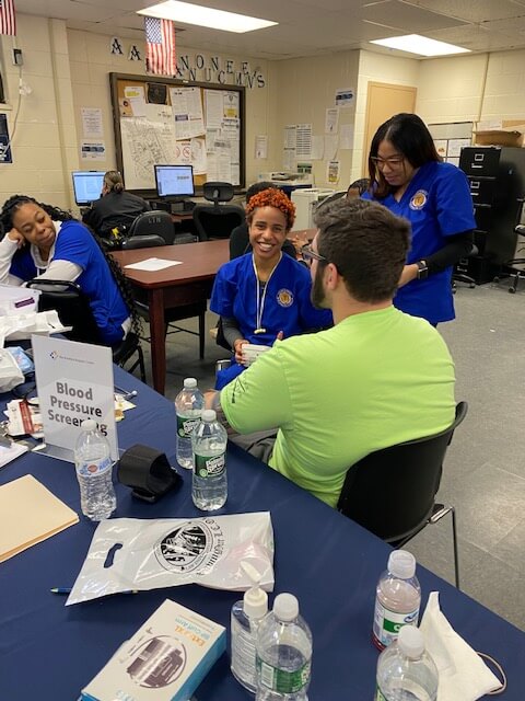 Volunteers screening visitors at a table