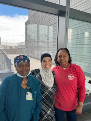 Three women posing together at a health fair