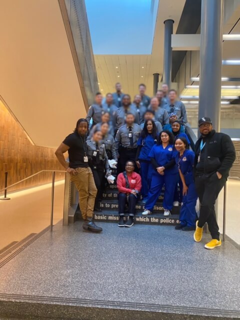 Large group of volunteers in blue posing together
