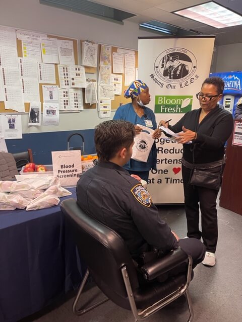 Man seated at a screening table with volunteers