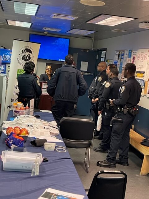 Volunteers and officers in a station room screening area