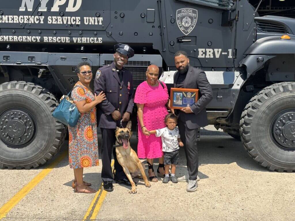 Visitors posing in front of an NYPD Emergency Service Unit vehicle