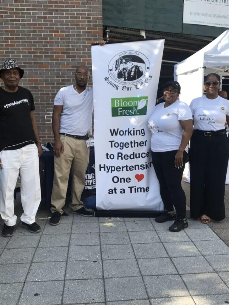 Volunteers posing beside a Saving Our Leos banner