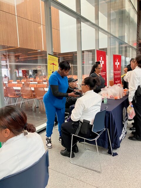 Nurses screening visitors at tables
