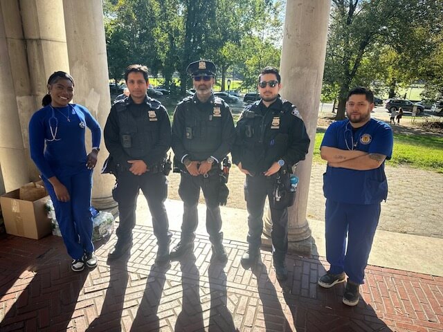 Officers and volunteers posing under a pavilion