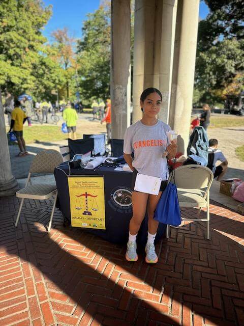 Volunteer at a table under a pavilion